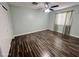 Bedroom with wood-look floors, a ceiling fan, and a window dressed with sheer curtains, providing a bright, airy atmosphere at 3810 N 106Th Dr, Avondale, AZ 85392