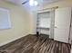 Bedroom with stylish wood floors, window, and built-in shelves in closet at 3810 N 106Th Dr, Avondale, AZ 85392