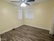 Bedroom with stylish wood floors, two windows, and a ceiling fan at 3810 N 106Th Dr, Avondale, AZ 85392