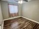 This bedroom features wood flooring and a window with curtains at 3810 N 106Th Dr, Avondale, AZ 85392