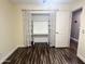 Bedroom with stylish wood floors and built-in shelves in closet at 3810 N 106Th Dr, Avondale, AZ 85392