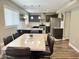 Modern kitchen with dark cabinets, stainless steel appliances, and a dining table with leather chairs at 3810 N 106Th Dr, Avondale, AZ 85392