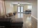 Open-concept living and dining area with a grey, tufted sectional sofa and plenty of room at 3810 N 106Th Dr, Avondale, AZ 85392