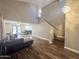 Spacious living area leading to dining, with a grey, tufted sofa and open floor plan at 3810 N 106Th Dr, Avondale, AZ 85392