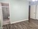 Main bedroom with wood-look floors leading into en suite bath with updated shower; great natural light from open hallway at 3810 N 106Th Dr, Avondale, AZ 85392