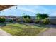 An inviting backyard with manicured grass, a brick-paved patio, and lush landscaping for privacy and beauty at 3844 E Shomi St, Phoenix, AZ 85044