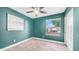 This bedroom features blue walls, carpet, a modern ceiling fan, and a window with neighborhood views at 3844 E Shomi St, Phoenix, AZ 85044