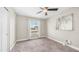 This cozy bedroom features carpet, a ceiling fan, and a bright window with neighborhood views at 3844 E Shomi St, Phoenix, AZ 85044