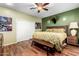 Cozy bedroom featuring hardwood floors, a ceiling fan, and neutral decor at 4637 E Narrowleaf Dr, Gilbert, AZ 85298