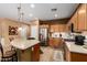 Well-lit kitchen with stainless steel refrigerator, granite counters, and tile flooring at 4637 E Narrowleaf Dr, Gilbert, AZ 85298