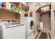 Well-equipped laundry room with modern washer and dryer, shelving, and storage solutions at 4637 E Narrowleaf Dr, Gilbert, AZ 85298