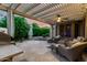 Cozy outdoor patio with comfortable seating, a pergola, and manicured landscaping at 4637 E Narrowleaf Dr, Gilbert, AZ 85298