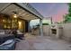 Elegant outdoor patio featuring a built-in grill, fireplace, and comfortable seating area at 4637 E Narrowleaf Dr, Gilbert, AZ 85298
