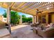 Inviting covered patio with ample seating, stone floors and an outdoor grill for relaxing and entertaining at 4637 E Narrowleaf Dr, Gilbert, AZ 85298