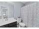 Well-lit bathroom featuring a floral shower curtain and modern sink at 5026 S 235Th Dr, Buckeye, AZ 85326