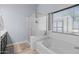 Bright bathroom featuring a glass shower, a soaking tub, and natural light at 5026 S 235Th Dr, Buckeye, AZ 85326