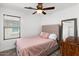 Cozy bedroom with neutral walls, ceiling fan, and a large mirror at 5026 S 235Th Dr, Buckeye, AZ 85326