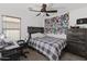 Bedroom features ceiling fan, window, a desk and dresser at 5026 S 235Th Dr, Buckeye, AZ 85326