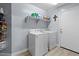 Well-organized laundry room with washer, dryer, and shelving for storage at 5026 S 235Th Dr, Buckeye, AZ 85326