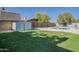 Backyard featuring green grass, a shed, and a pool, offering a perfect blend of recreation and storage at 5028 W Shangri La Rd, Glendale, AZ 85304