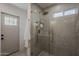 Bathroom with sleek glass-enclosed shower, grey tiling, and convenient door to outside at 5028 W Shangri La Rd, Glendale, AZ 85304