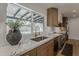 Modern kitchen with stainless steel appliances, marble countertops, and a view to the backyard pool area at 5028 W Shangri La Rd, Glendale, AZ 85304