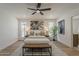 Light-filled main bedroom with a ceiling fan, decorative art, and view of the backyard at 5028 W Shangri La Rd, Glendale, AZ 85304