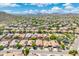 Expansive aerial view of a community with desert landscaping, tile roofs and solar panels nestled among mountains at 5123 W Redbird Rd, Phoenix, AZ 85083