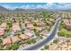Picturesque aerial view of a desert community featuring tile roofs, swimming pools, and a paved road at 5123 W Redbird Rd, Phoenix, AZ 85083