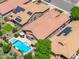 Bird's eye view of backyards with sparkling pool, desert landscaping and solar panels on rooftops in gated community at 5123 W Redbird Rd, Phoenix, AZ 85083
