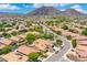 Stunning aerial view of a neighborhood with lush desert landscaping, and mountain views under a bright blue sky at 5123 W Redbird Rd, Phoenix, AZ 85083