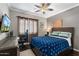 Inviting bedroom with ceiling fan, window, desk, television, and blue-themed bedding at 5123 W Redbird Rd, Phoenix, AZ 85083