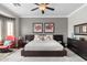 Modern bedroom with dark wood furniture, a ceiling fan, and neutral gray walls at 5123 W Redbird Rd, Phoenix, AZ 85083
