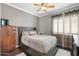 Comfortable bedroom features a ceiling fan, window with blinds, and closet for storage at 5123 W Redbird Rd, Phoenix, AZ 85083
