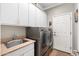 Functional laundry room with ample storage cabinets and modern washer and dryer at 5123 W Redbird Rd, Phoenix, AZ 85083