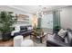 Comfortable living room featuring a leather sofa, stylish decor, and a large window providing natural light and shutter shades at 5123 W Redbird Rd, Phoenix, AZ 85083