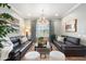 Bright living room boasts neutral paint, updated lighting, and plush leather sofas at 5123 W Redbird Rd, Phoenix, AZ 85083