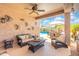 Relaxing covered patio with ceiling fan and outdoor furniture overlooking a sparkling pool and dining area at 5123 W Redbird Rd, Phoenix, AZ 85083