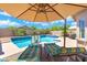 Inviting pool area featuring a spa, lounging chairs, and lush palm trees, perfect for relaxation and recreation at 5123 W Redbird Rd, Phoenix, AZ 85083