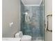 Shower room with unique blue tiling, upgraded fixtures, and refined glass door at 5123 W Redbird Rd, Phoenix, AZ 85083