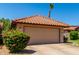 Attractive garage with a tile roof and a well-maintained front yard with lush greenery at 5216 E Half Moon Dr, Phoenix, AZ 85044
