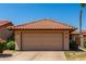 Charming home featuring a two-car garage with a tile roof, set against a clear blue sky at 5216 E Half Moon Dr, Phoenix, AZ 85044