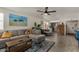 Open-concept living room with a plush gray sectional, stylish decor, and a ceiling fan at 5216 E Half Moon Dr, Phoenix, AZ 85044
