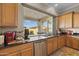 Kitchen counter with cabinets overlooking the backyard with retractable wall and stainless steel dishwasher at 5258 S Verde --, Mesa, AZ 85212