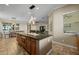 Kitchen island with seating, granite countertops, and modern light fixtures with view to the living room at 5258 S Verde --, Mesa, AZ 85212