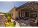 Cozy covered patio with elegant outdoor furniture, water feature, and desert landscaping at 5258 S Verde --, Mesa, AZ 85212