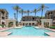 Community pool surrounded by palm trees, lounge chairs, and covered seating areas at 5303 N 7Th St # 331, Phoenix, AZ 85014
