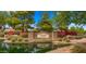 Charming community entrance with stone signage, manicured landscaping, mature trees, and a serene water feature at 549 E Benrich Dr, Gilbert, AZ 85295