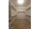 Walk-in closet featuring shelving, wood trim, and tile flooring at 549 E Benrich Dr, Gilbert, AZ 85295