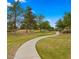 Scenic walking path through the community park with well-maintained landscaping and mature trees at 549 E Benrich Dr, Gilbert, AZ 85295